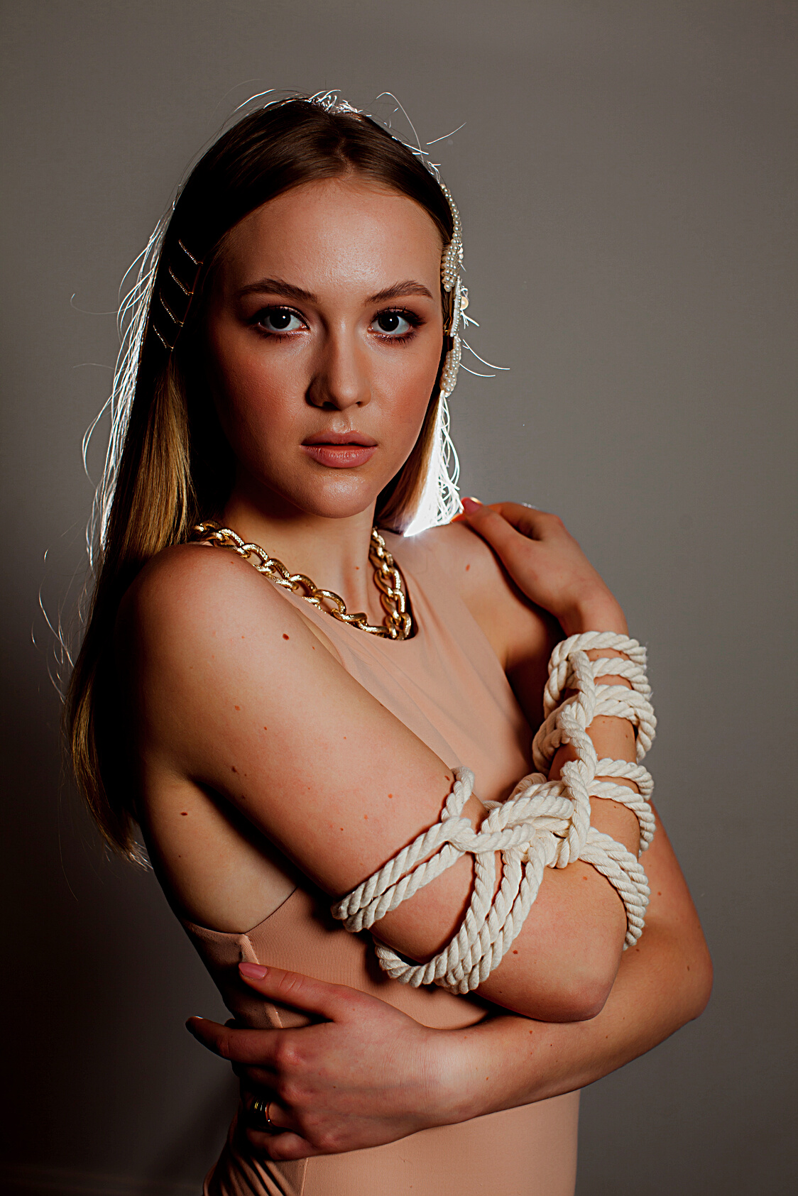 Fashion Girl with Rope Strap on Her Hand at Grey Background